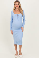 woman wearing a light blue ribbed maternity dress with a tie detail and a visible baby bump