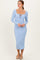 woman wearing a light blue ribbed long sleeve midi dress with a square neckline and tie detail at the chest