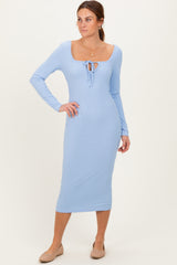 woman wearing a light blue long sleeve ribbed midi dress with a square neckline and tie detail at the front