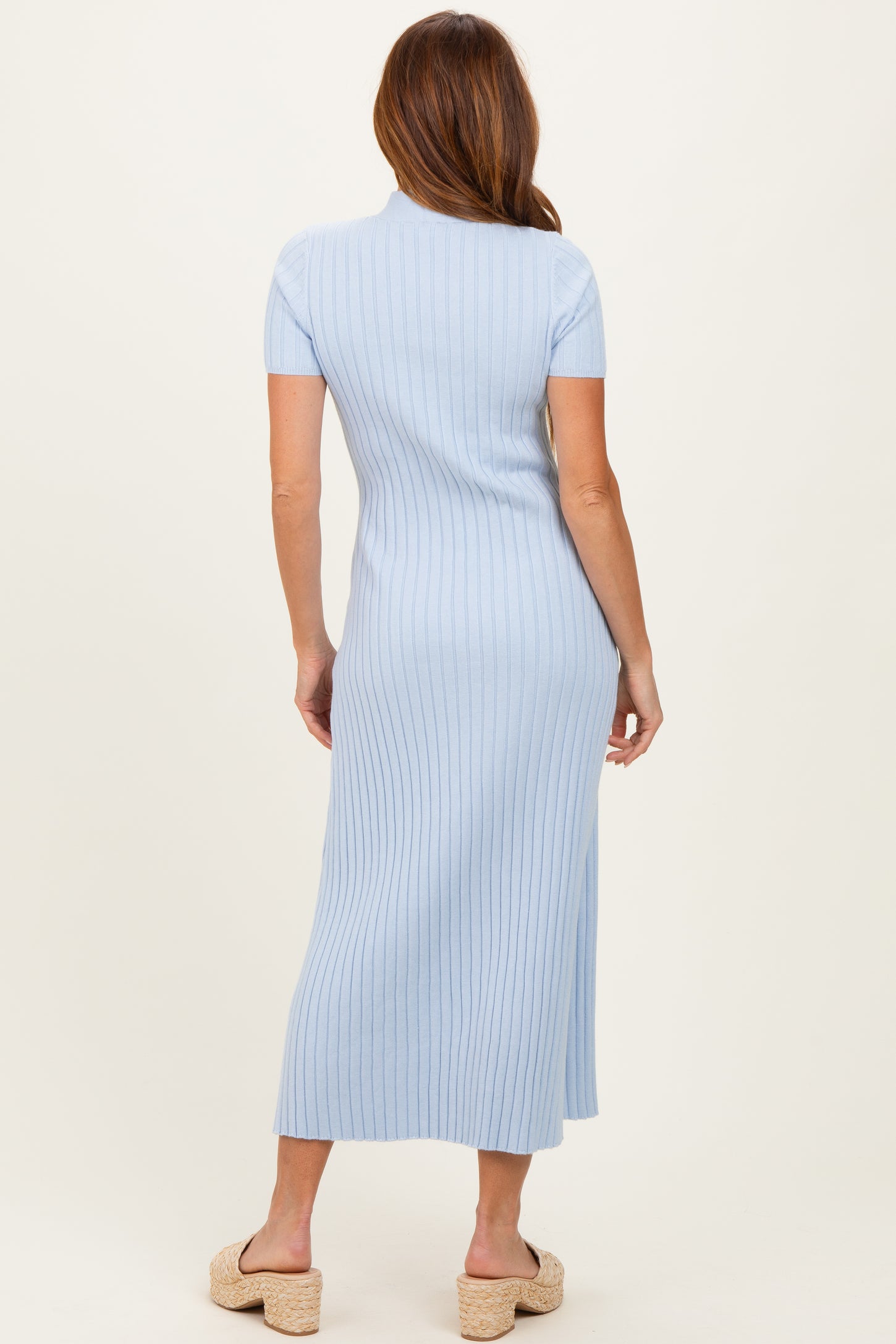woman wearing a light blue ribbed midi dress with short sleeves and a fitted silhouette, viewed from the back