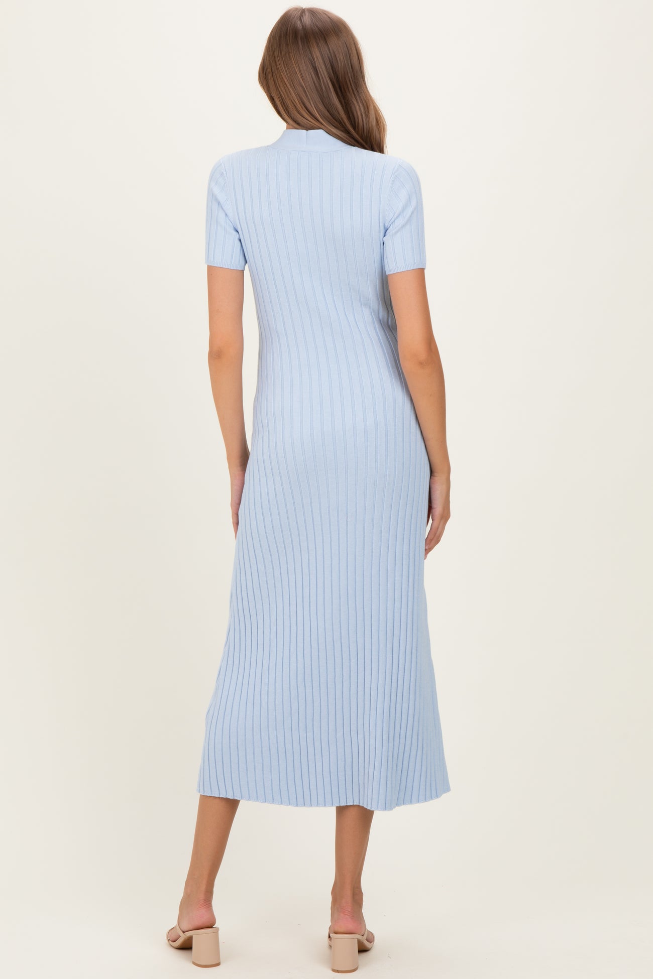 woman wearing a light blue short sleeve ribbed maternity dress with a fitted silhouette and midi length