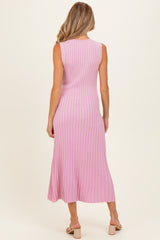 woman wearing a pink ribbed midi maternity dress, showing the back view and featuring a fitted style