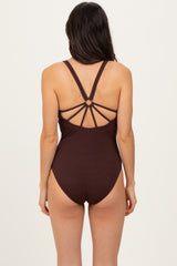 woman wearing a burgundy ribbed one-piece swimsuit with strappy back details