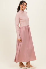 woman wearing a blush pink long sleeve ribbed top and a flowing maxi skirt, styled in an elegant silhouette
