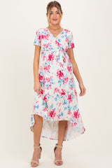 woman wearing a floral maternity dress with a tie waist and high-low hem, showcasing her baby bump