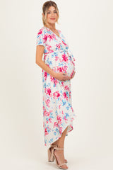 woman wearing a floral maternity maxi dress with a tied waist and holding her baby bump