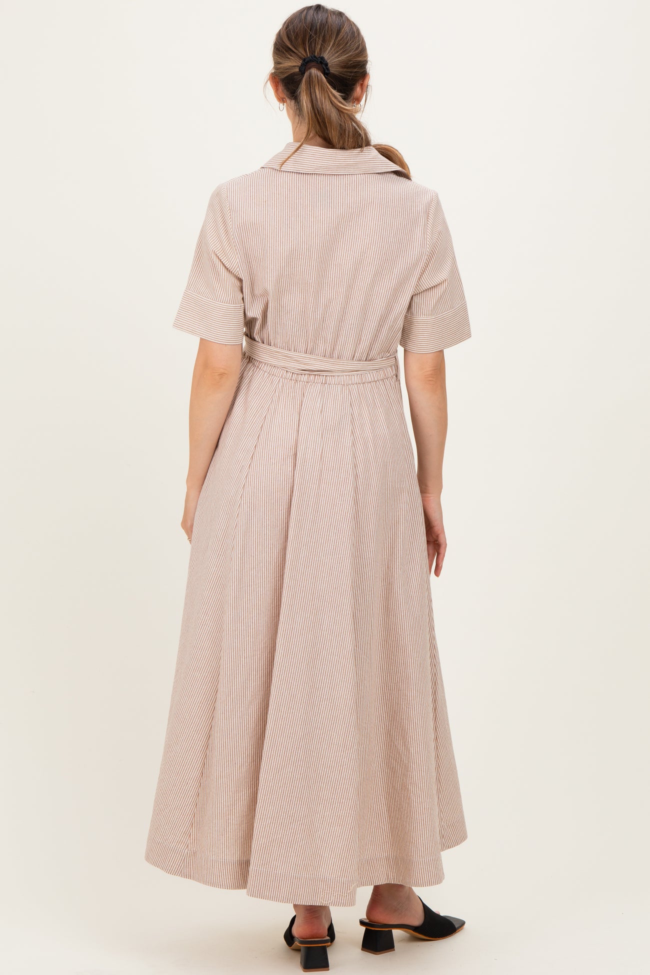 woman wearing a striped maternity dress with short sleeves and a tied waist, shown from the back