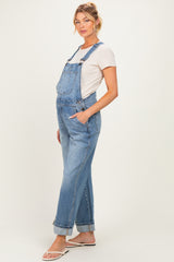 woman wearing a light blue maternity overall with rolled cuffs and a fitted t-shirt, showcasing a baby bump
