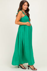 woman wearing a green maternity maxi dress with ruffled straps and a baby bump visible