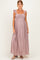 woman wearing a mauve maternity maxi dress with ruffle details and a smocked bodice, showcasing her baby bump