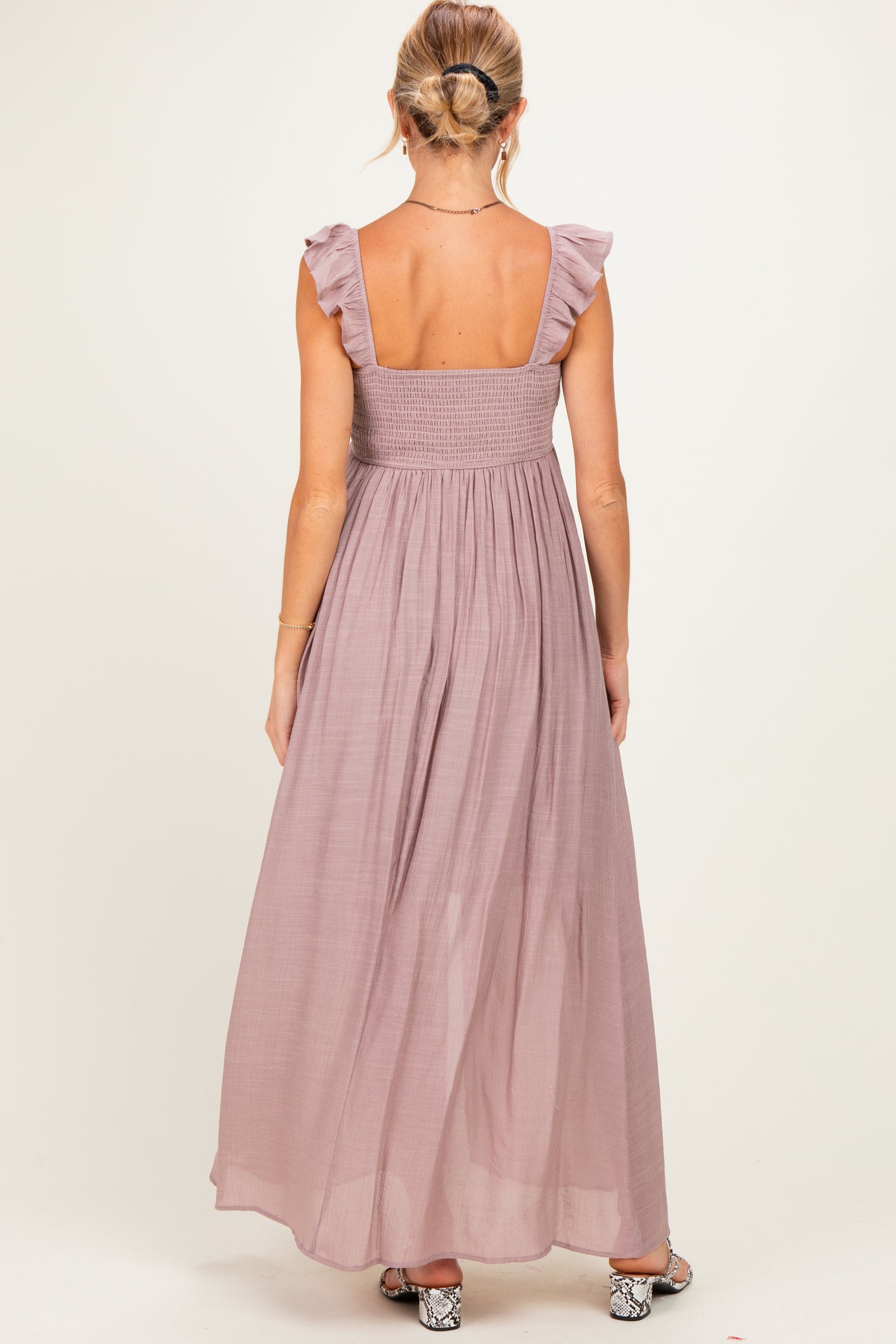 woman wearing a mauve maternity maxi dress with ruffle straps and a smocked back detailing