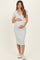 woman wearing a light blue striped maternity dress with a deep v-neck and short sleeves, holding her baby bump