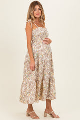 woman wearing a floral print maternity dress with adjustable straps and a baby bump visible