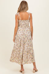 woman wearing a floral print maternity dress with tie straps and a smocked back, showing a long flowy skirt