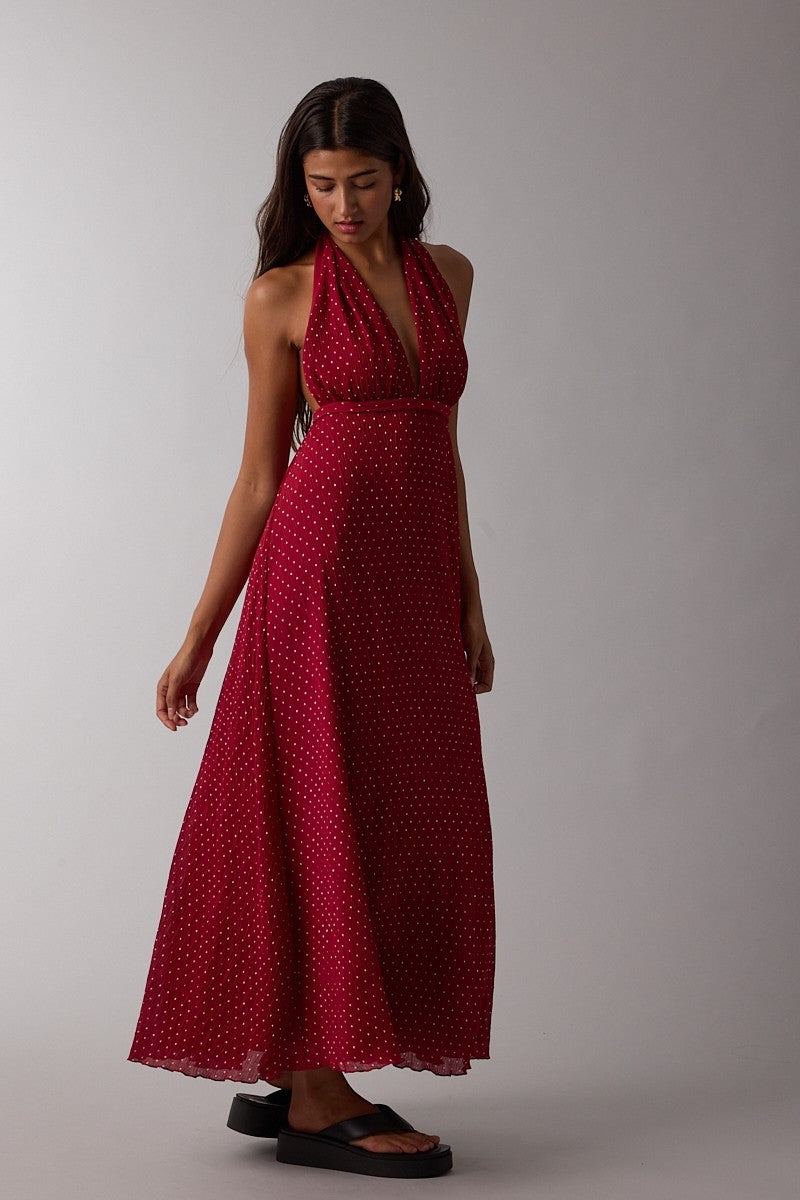woman wearing a red polka dot halter neck maxi dress with a flowing silhouette and a fitted bodice