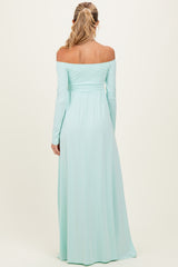 woman wearing a mint green off-the-shoulder maternity maxi dress from the back