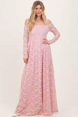 woman wearing a long pink off-the-shoulder lace maxi dress with long sleeves and a flowing skirt