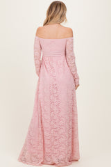 woman wearing a blush pink off-the-shoulder lace maxi dress with long sleeves, seen from the back