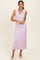 woman wearing a light pink sleeveless ribbed midi dress with a v-neck and collar, styled with neutral pointed-toe heels