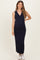 woman wearing a navy blue sleeveless ribbed maternity dress and showing her baby bump