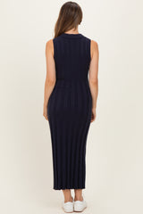 woman wearing a navy blue ribbed sleeveless maternity dress, showing a fitted silhouette and ankle-length design