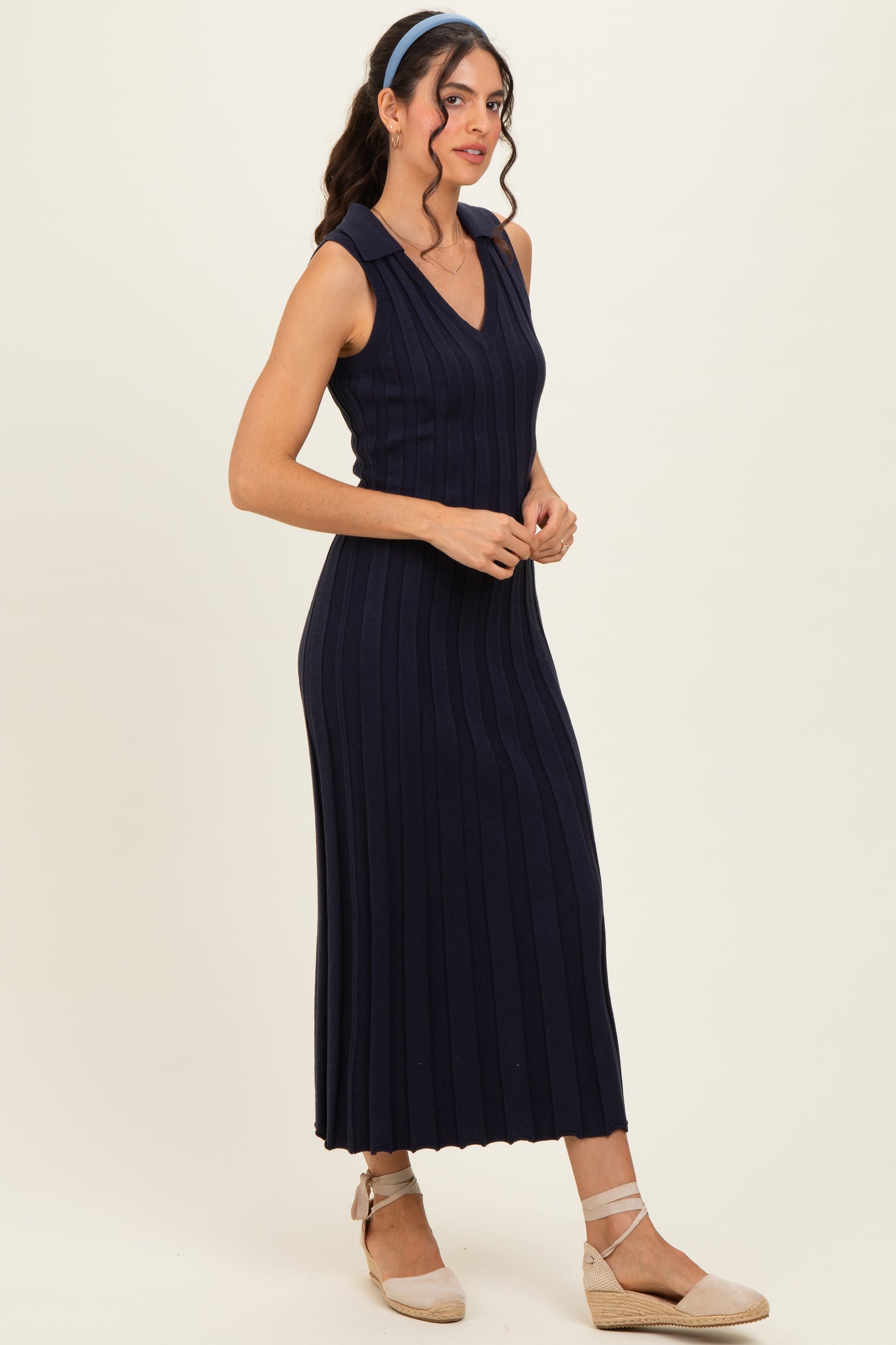 woman wearing a navy ribbed sleeveless midi dress with a v-neckline and styled with light brown espadrille flats
