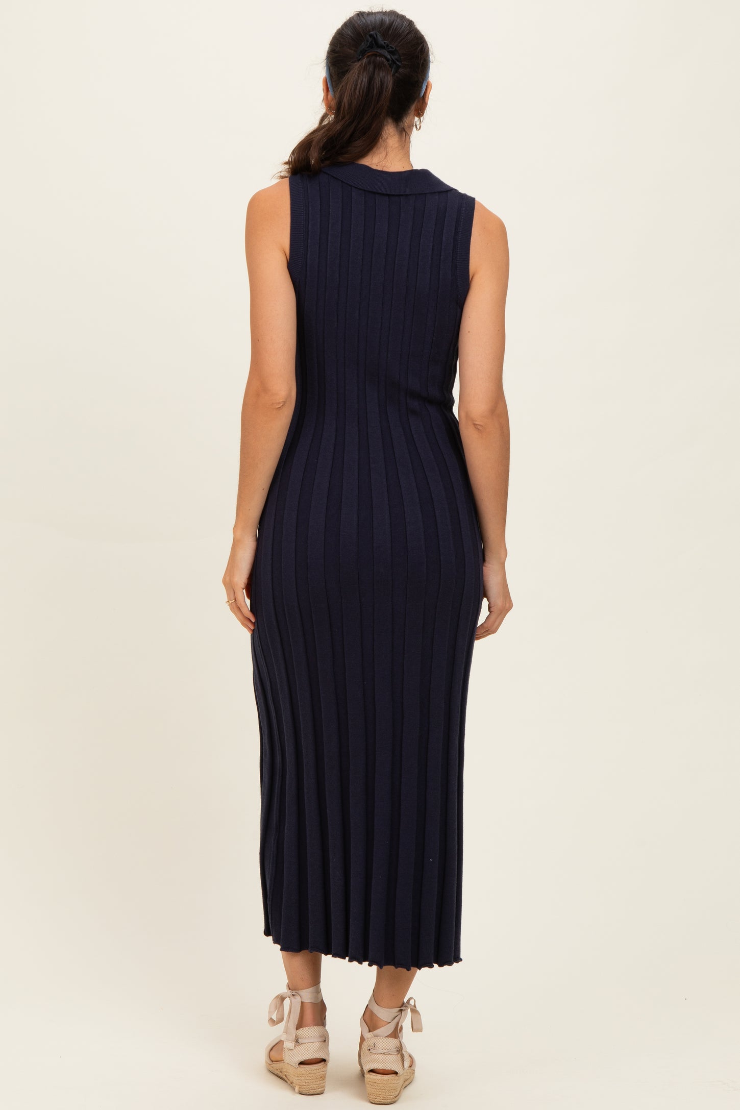 woman wearing a navy ribbed sleeveless maxi dress, viewed from the back