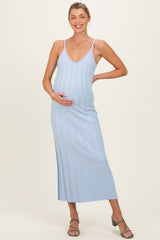woman wearing a light blue ribbed maternity dress with a v-neckline and holding her baby bump