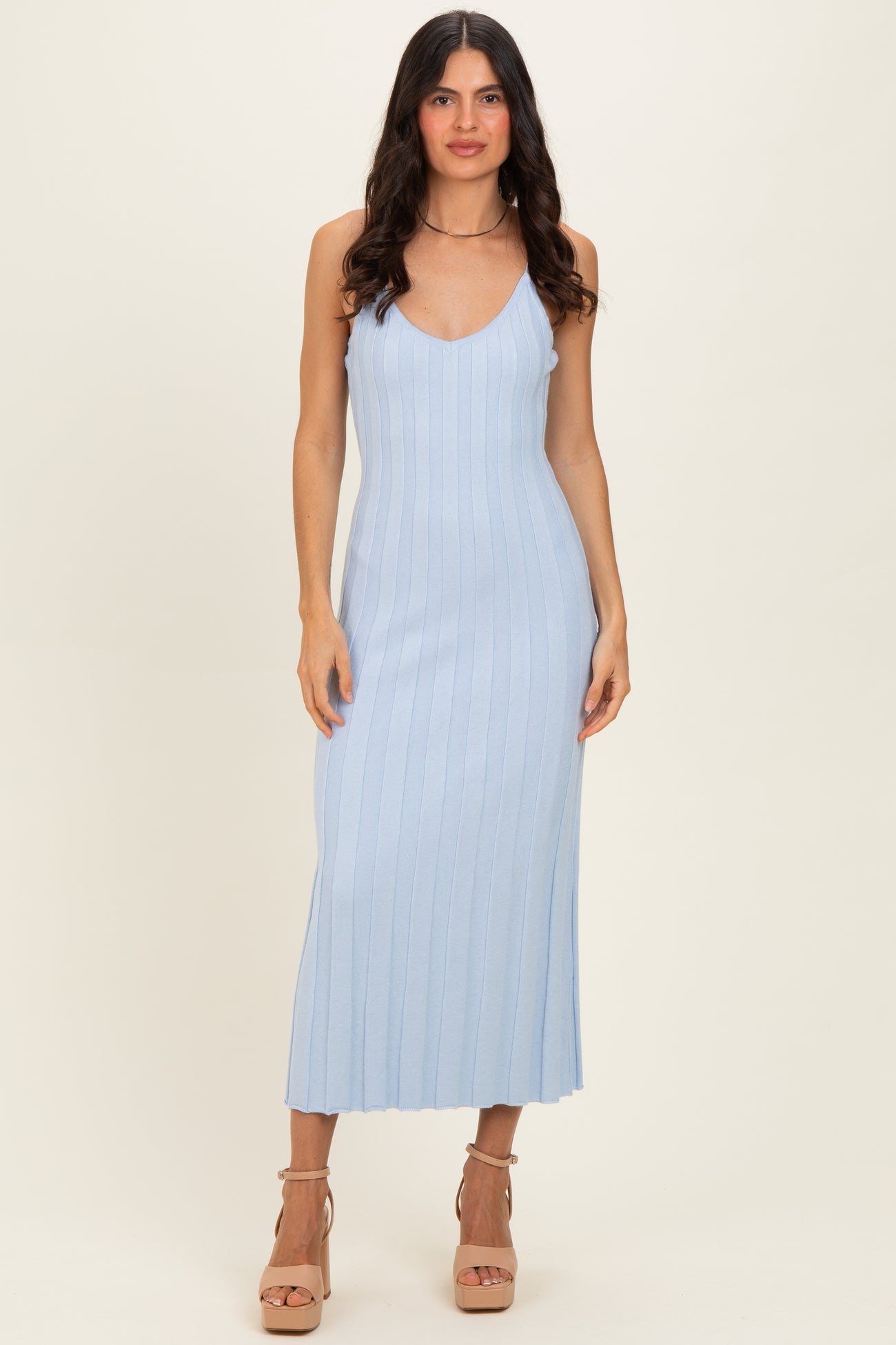 woman wearing a light blue ribbed knit maxi dress with a deep v-neck and spaghetti straps