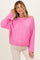 woman wearing a bright pink oversized maternity cardigan with buttons, styled casually over a white top and light pants