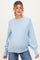 woman wearing a light blue oversized maternity sweater with balloon sleeves and a visible baby bump