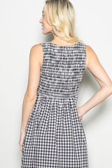 woman wearing a black and white gingham dress with a smocked back and sleeveless design