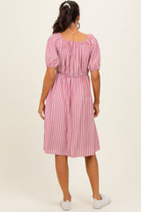 woman wearing a pink and white striped short sleeve dress with a cinched waist and a midi length