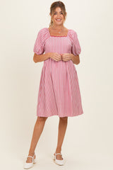 woman wearing a pink and white striped maternity dress with puff sleeves and a square neckline
