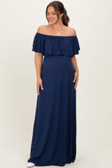 woman wearing a navy blue off-shoulder maternity maxi dress with ruffled sleeves and a relaxed fit, showing her baby bump