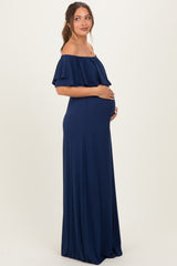 woman wearing a navy blue off-the-shoulder maternity dress, cradling her baby bump