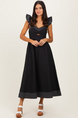 woman wearing a black maxi dress with striped puff sleeves and a cutout detail at the waist