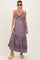 woman wearing a printed purple maternity maxi dress with a knot detail and a fitted bodice, displaying her baby bump