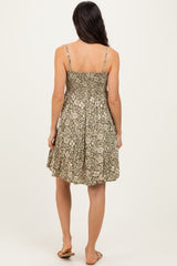 woman wearing a back view of a green floral print sundress with spaghetti straps and a flowy silhouette