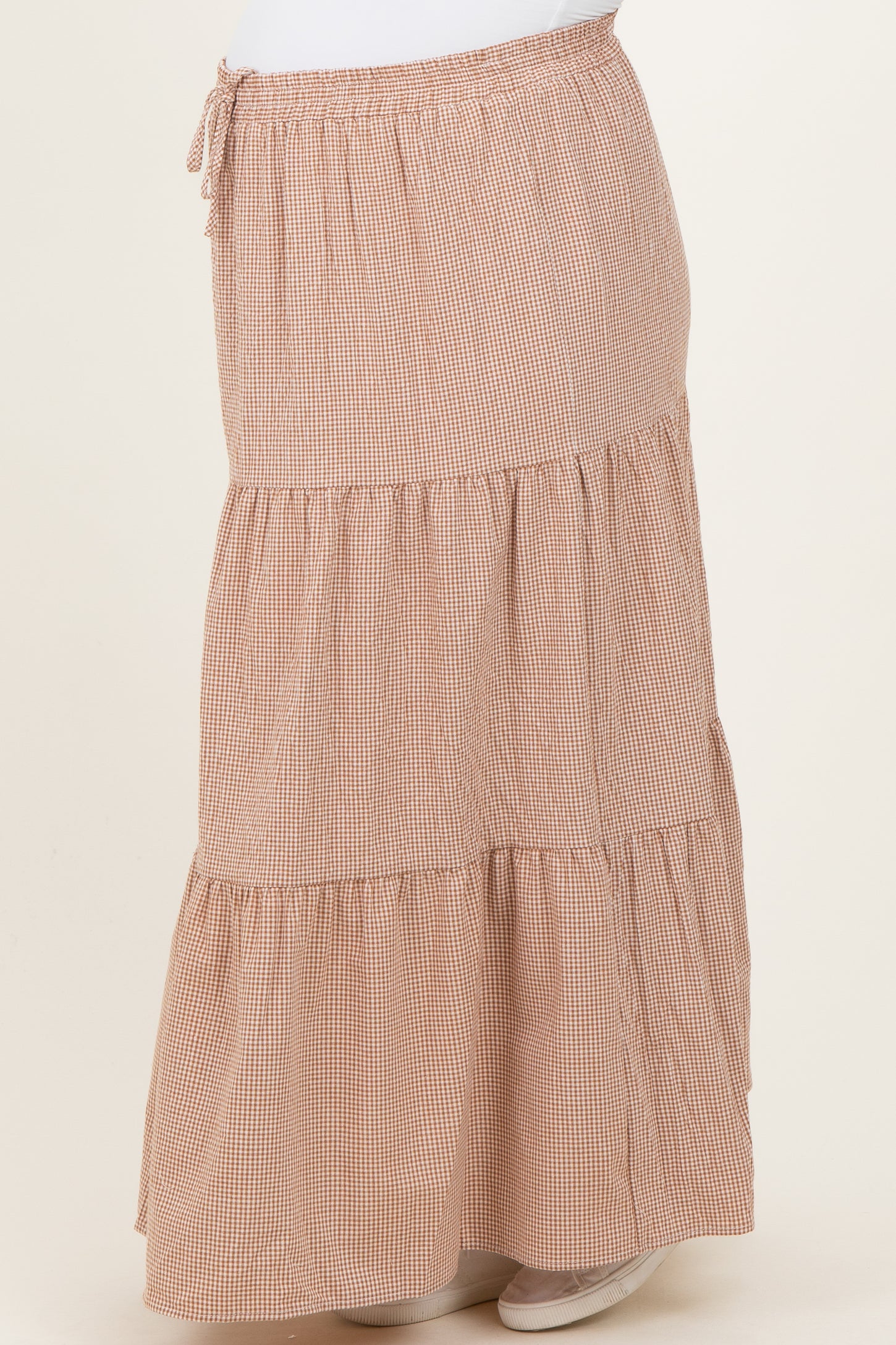 maternity wear in a brown checkered tiered maxi skirt with an adjustable drawstring waistband