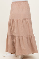 woman wearing a checkered brown maternity maxi skirt with a tiered design and elastic waistband