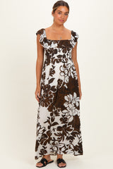 woman wearing a brown and white floral maternity maxi dress with ruffle sleeves and a smocked bodice, showcasing her baby bump