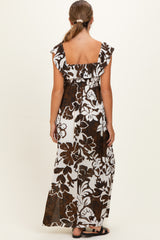 woman wearing a brown and white floral maxi maternity dress with ruffled sleeves and an elastic waist from the back