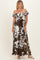 woman wearing a brown and white floral off-the-shoulder maxi dress with side slits and ruffle details