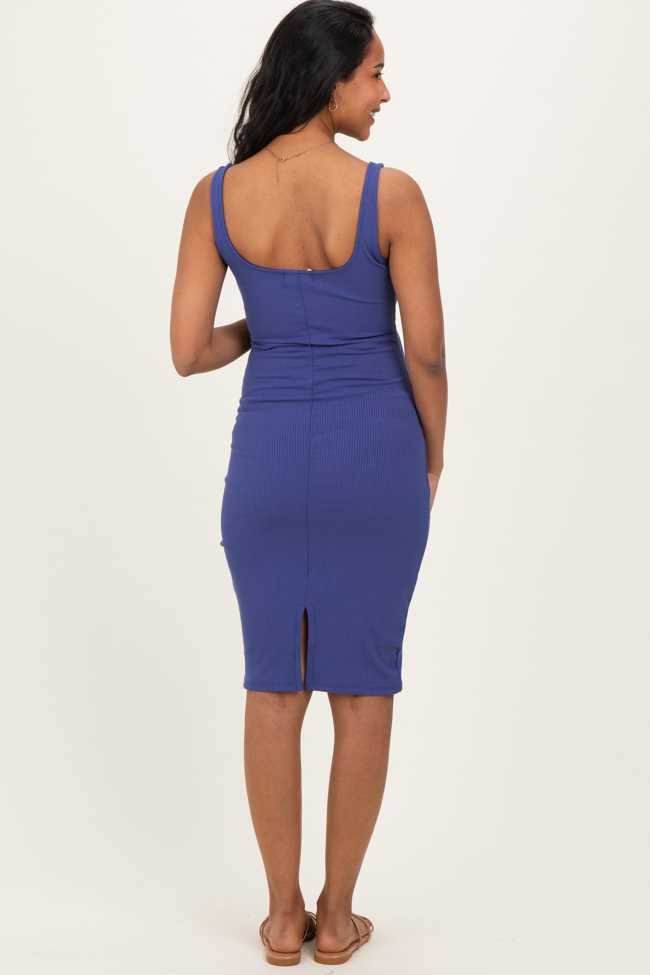 woman wearing a dark blue maternity dress with a fitted silhouette and back slit