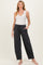 woman wearing a white ribbed tank top and dark gray maternity lounge pants with pockets and a drawstring waistband