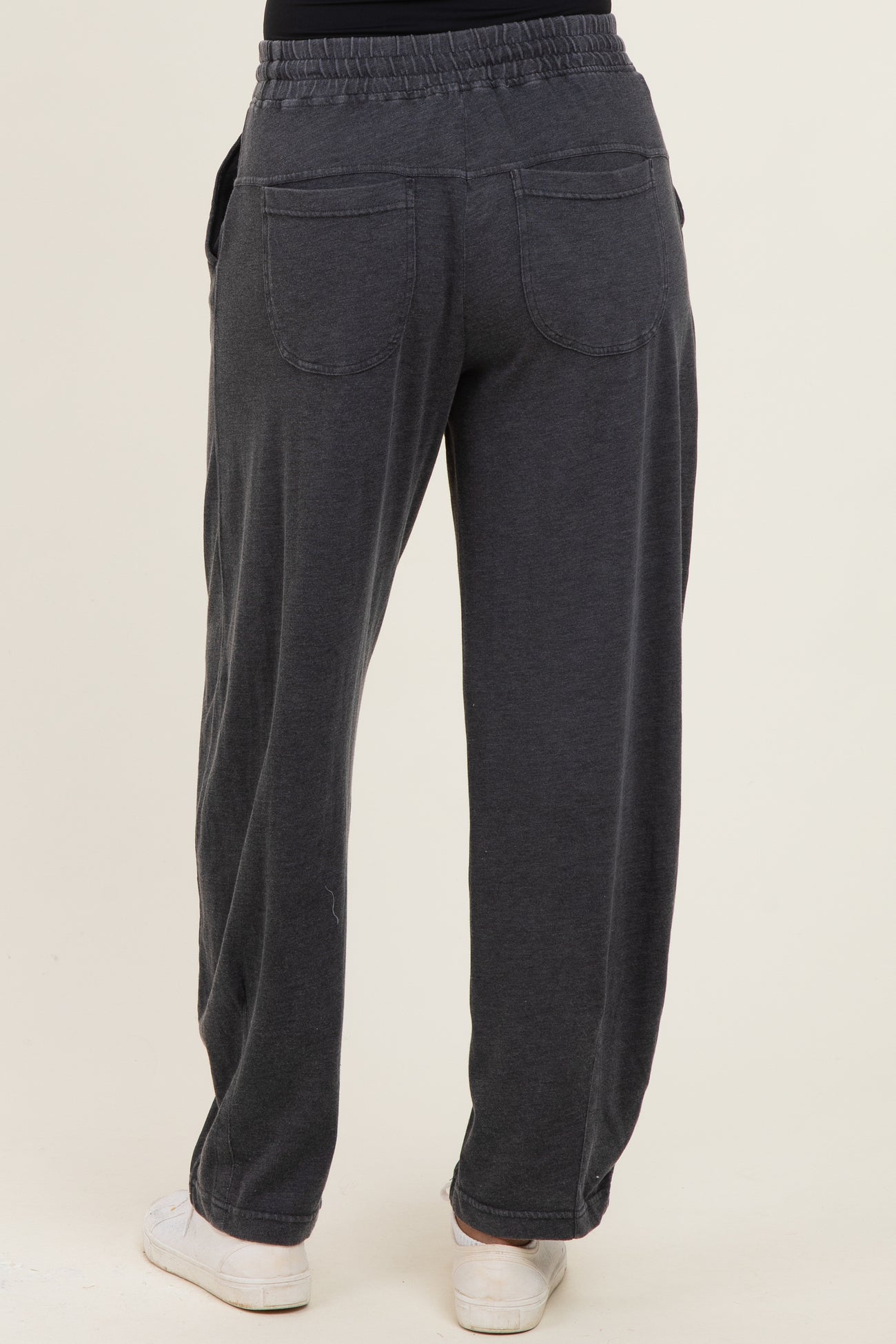 woman wearing dark gray relaxed fit sweatpants with pockets and a comfortable waistband, seen from the back