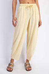 woman wearing light yellow relaxed fit drawstring pants with a wide leg and comfortable fabric