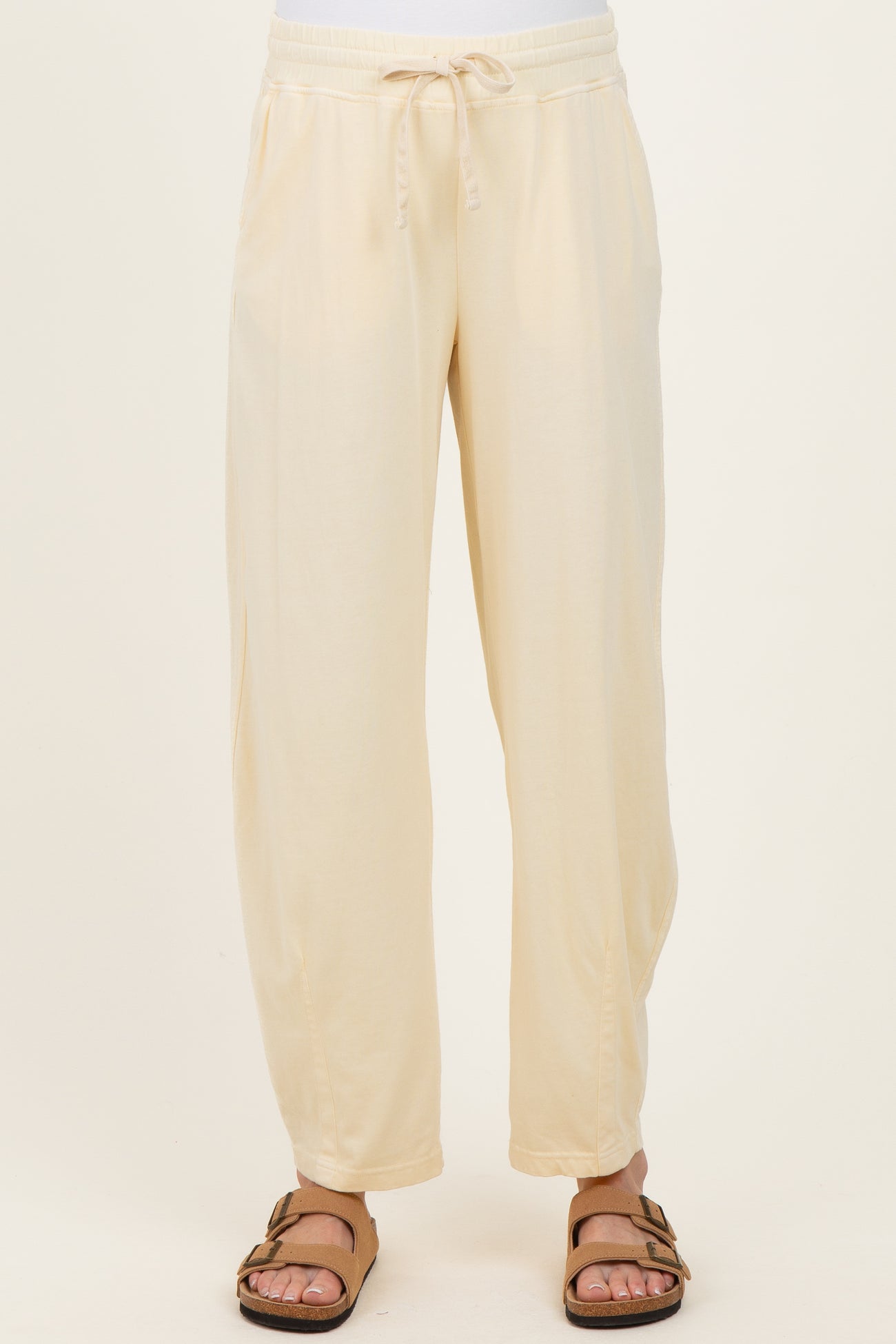 woman wearing cream maternity jogger pants with an elastic waistband and side pockets