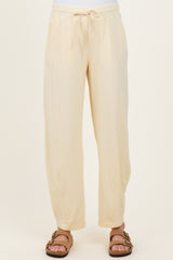 woman wearing cream maternity jogger pants with an elastic waistband and side pockets